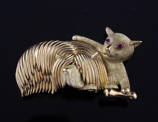 A French 18ct gold and ruby set novelty clip brooch, modelled as a dog and bone with a mischievous cat, 2in.